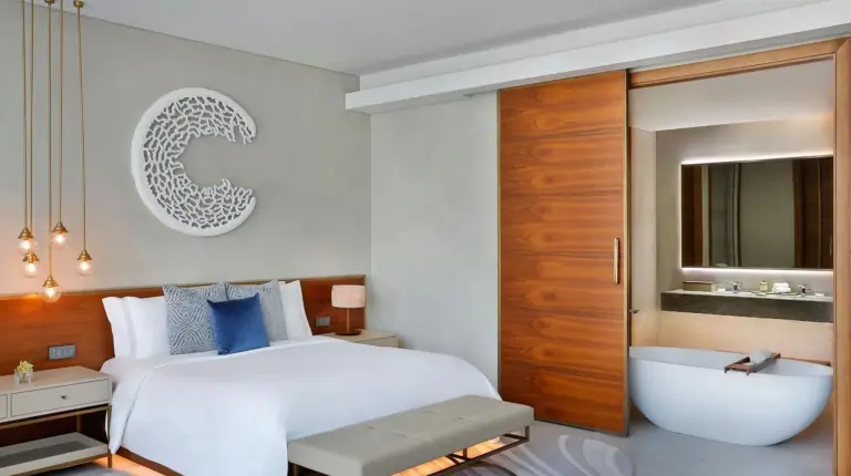 a bedroom with a large bed and a bath tub at The St. Regis Downtown Dubai in Dubai