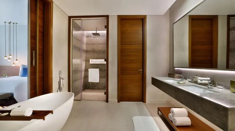 a bathroom with a tub and a sink and a bed at The St. Regis Downtown Dubai in Dubai