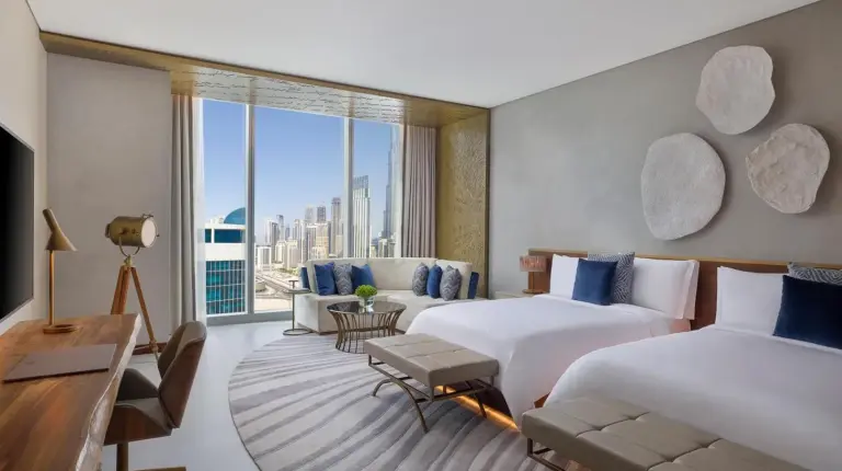 a hotel room with two beds and a large window at The St. Regis Downtown Dubai in Dubai