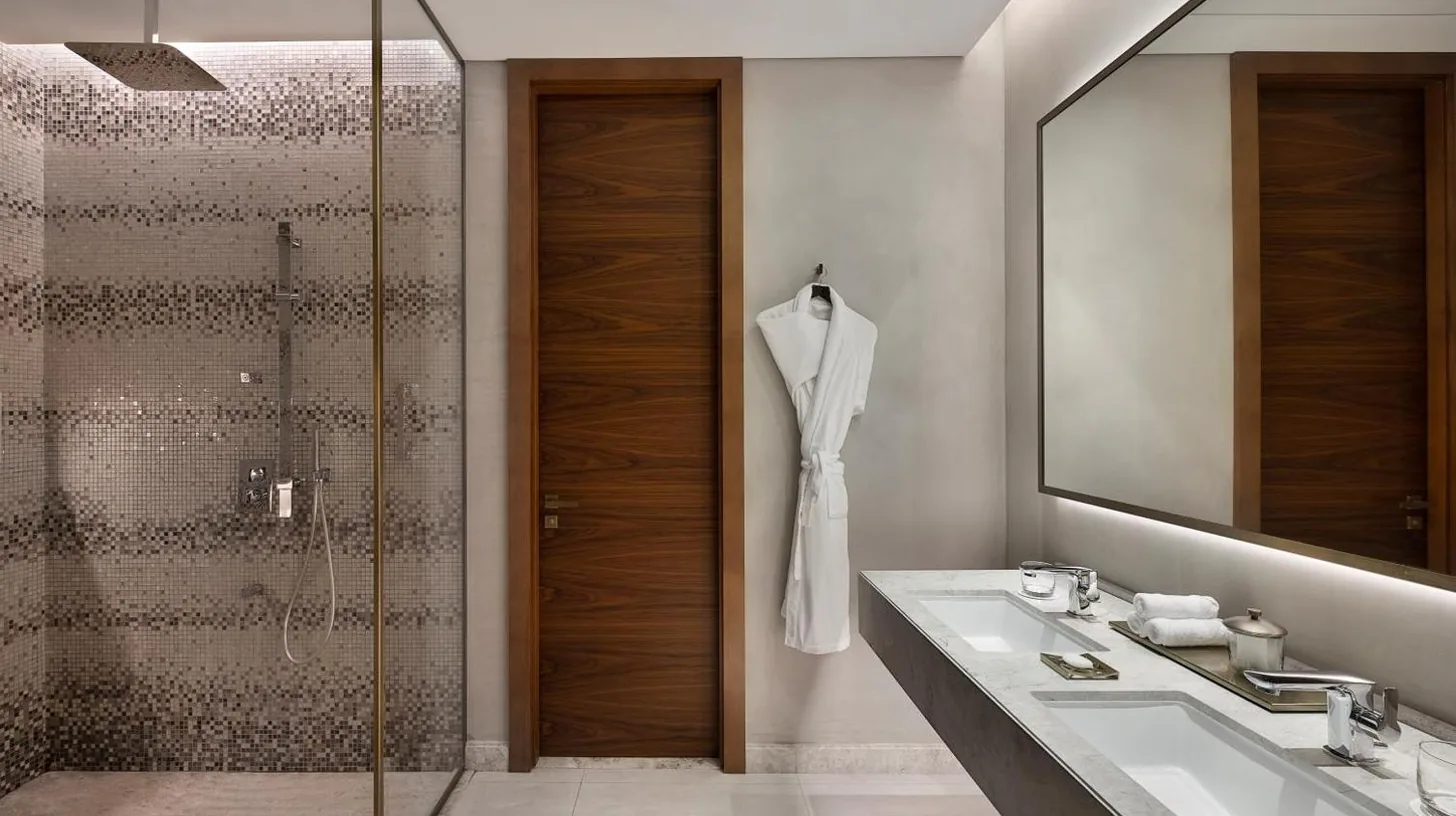 a bathroom with a shower and a sink and a mirror at The St. Regis Downtown Dubai in Dubai