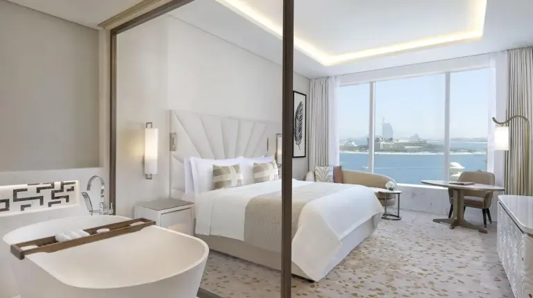 a white bathroom with a tub and a sink at The St. Regis Dubai