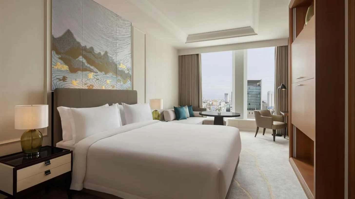 a hotel room with a large bed and a living room at The St. Regis Osaka in Osaka