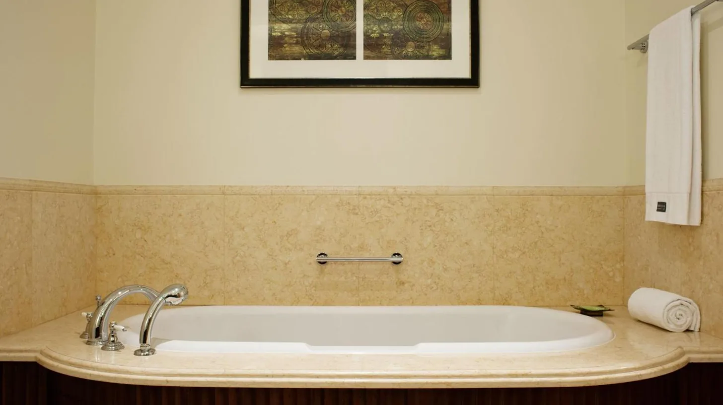 a bath tub in a bathroom with a picture on the wall at The Westin Dubai Mina Seyahi Beach Resort and Waterpark in Dubai