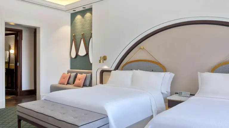 a hotel room with two beds and a chair at The Westin Dubai Mina Seyahi Beach Resort and Waterpark in Dubai
