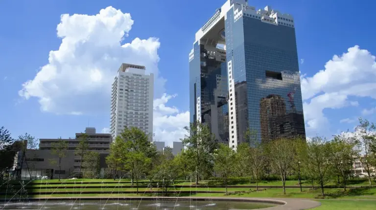 two tall buildings in a park with a fountain at The Westin Osaka in Osaka