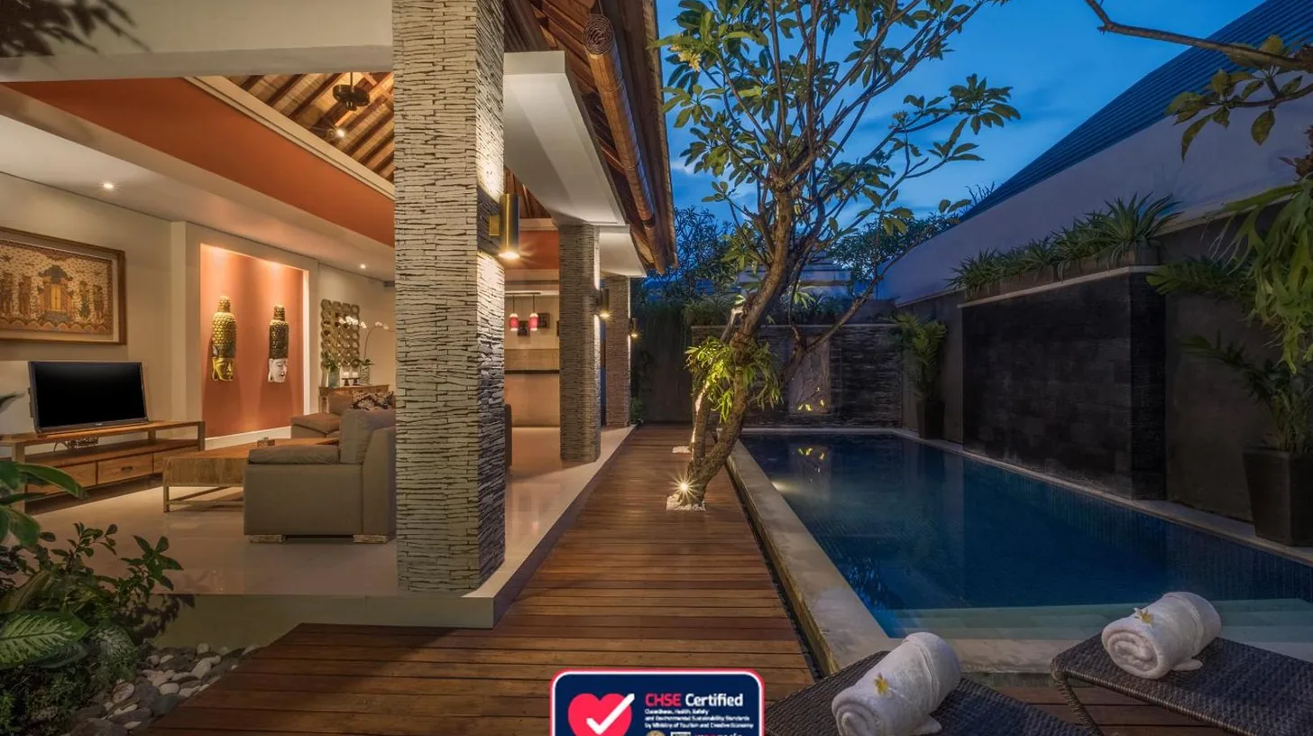 a villa with a swimming pool at night at The Wolas Villas in Seminyak