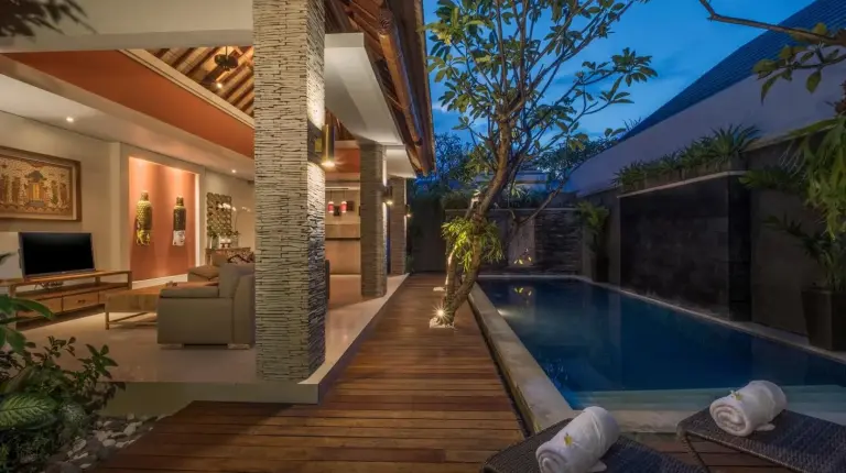 a house with a swimming pool and a living room at The Wolas Villas in Seminyak