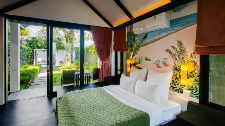 a bedroom with a bed with a green bedspread at Tolani Resort Koh Samui in Lamai