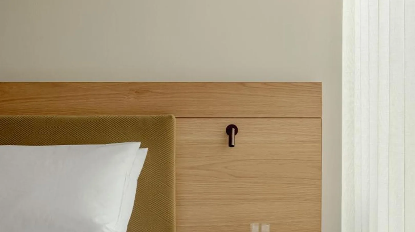 a bedroom with a bed with a wooden headboard and a side table at TRUNK(HOTEL) YOYOGI PARK in Tokyo