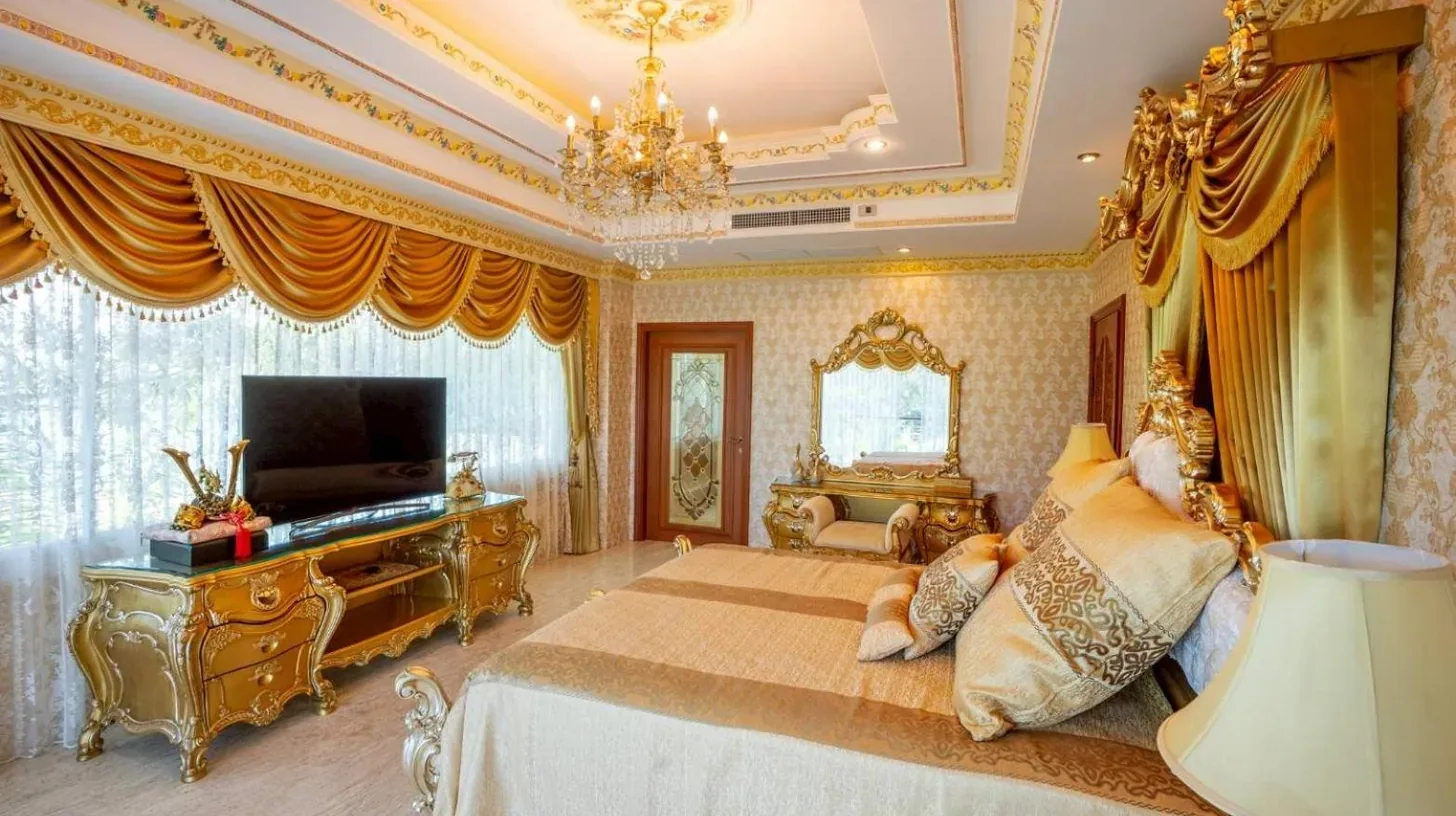 une chambre avec un grand lit et une télévision au Penthouse deux chambres vue mer Rawai Beach Phuket à Phuket Town