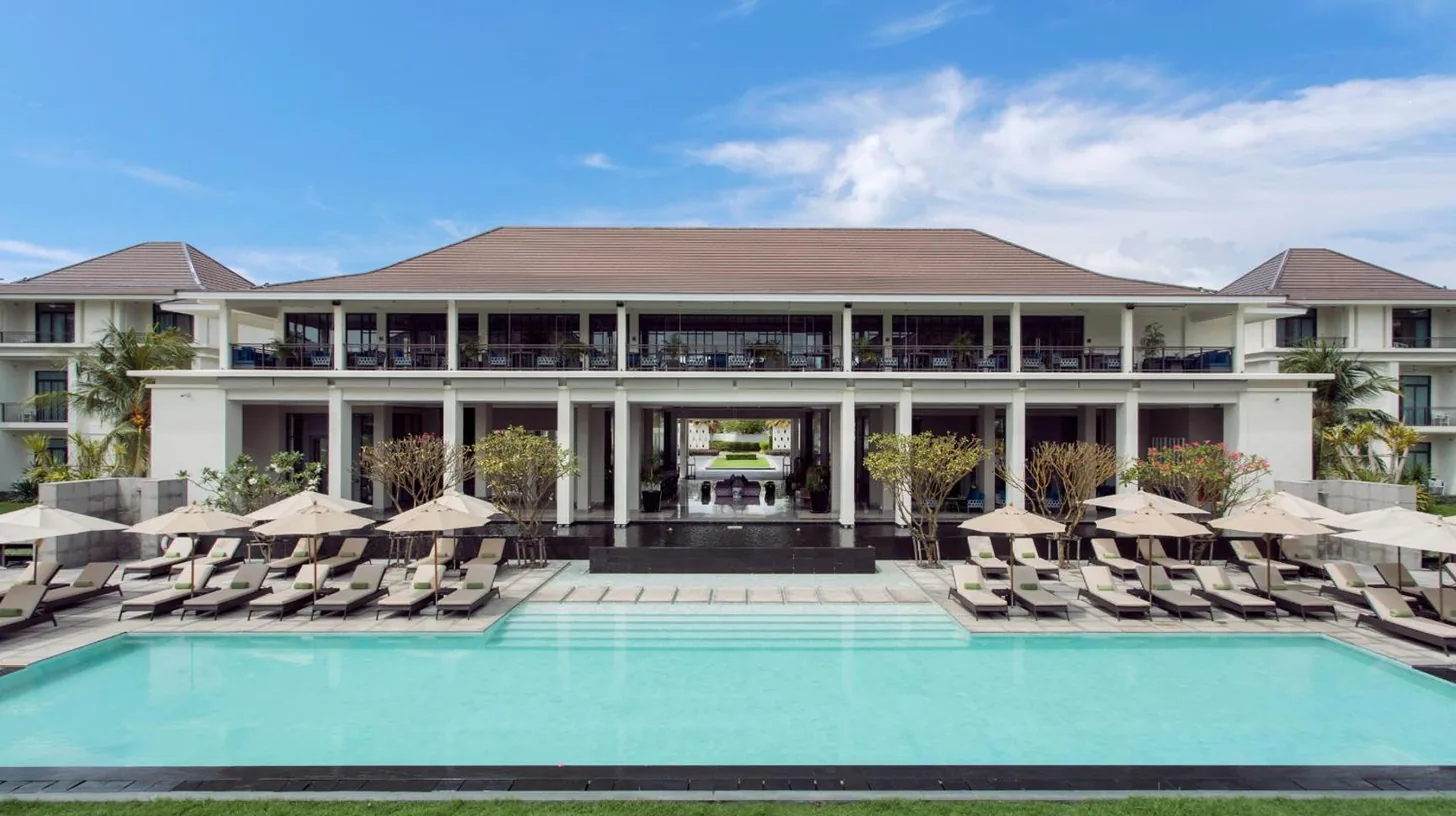 a resort with a pool and chairs and a building at U Sathorn Bangkok in Bangkok
