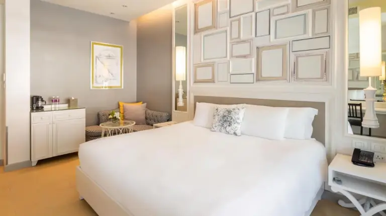 a bedroom with a large white bed and a desk at U Sathorn Bangkok in Bangkok