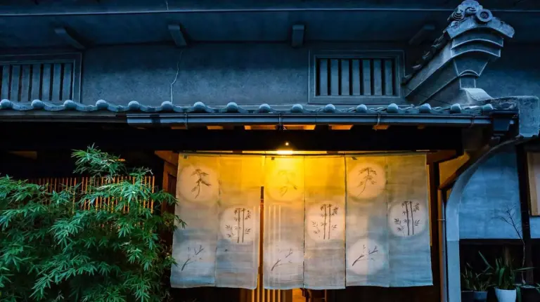 an entrance to a house with writing on the door at Udatsuya in Osaka