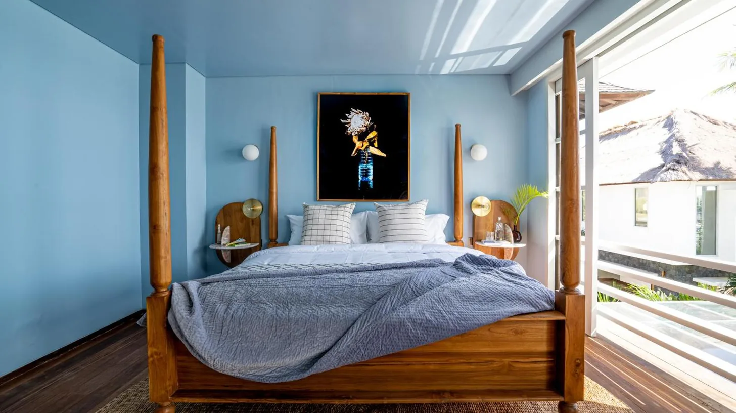 une chambre avec un lit et un mur bleu à Ulu Cliffhouse - Adults Only à Uluwatu