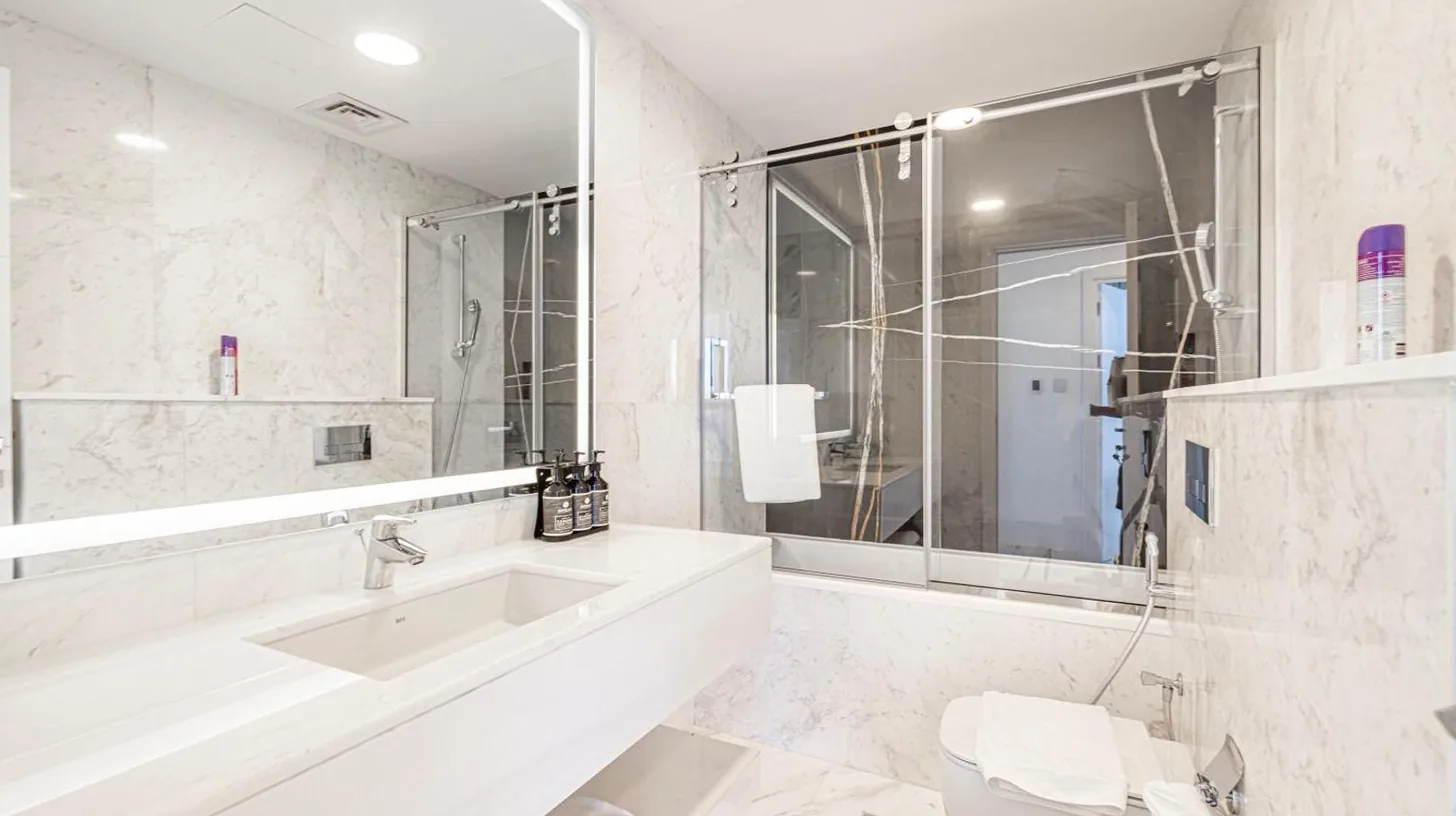 eine Küche mit weißen Schränken und Marmorboden bei Aufgerüstete Zwei‑Schlafzimmer‑Apartment in Marina in Dubai
