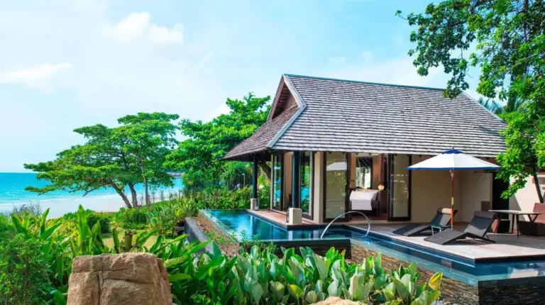 a villa with a swimming pool next to the ocean at Vana Belle