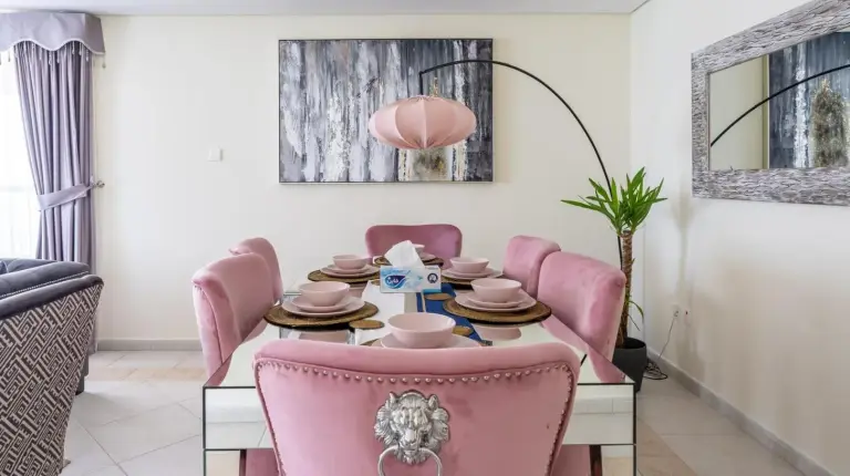 un comedor con una mesa y sillas rosas en Veer Apartments - 82nd Floor Princess Tower - Palm View en Dubái