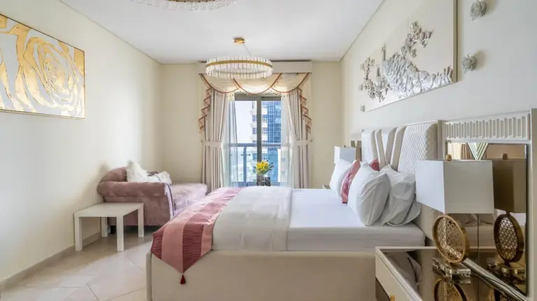 un dormitorio con una cama grande y una lámpara de araña en Veer Apartments - 82nd Floor Princess Tower - Palm View en Dubái