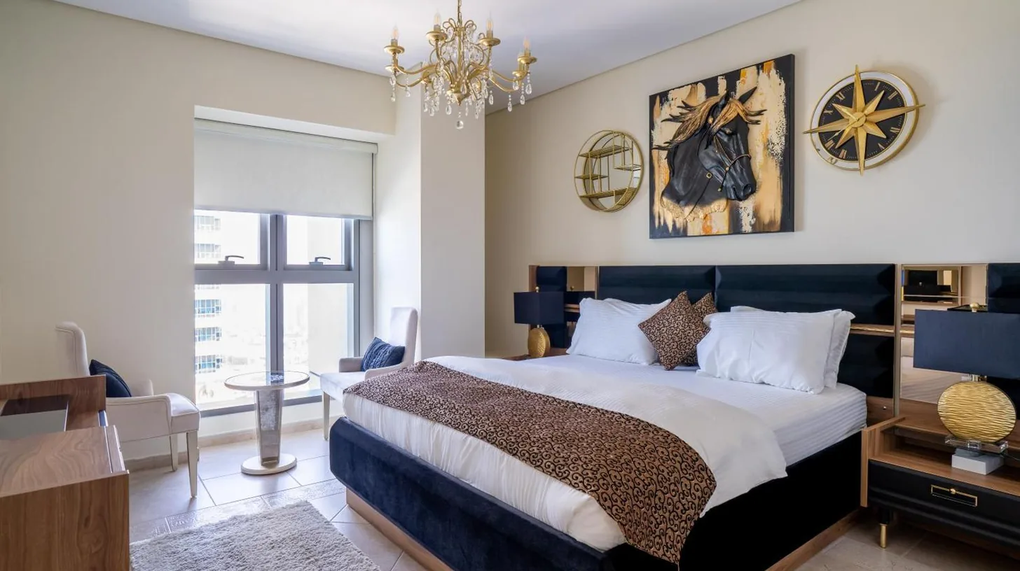 un dormitorio con una cama y dos relojes en la pared en Veer Apartments - 82nd Floor Princess Tower - Palm View en Dubái