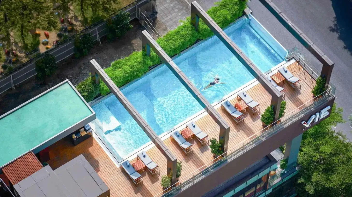 an overhead view of a swimming pool with lounge chairs and a pool at VIE Hotel Bangkok - MGallery Collection in Bangkok