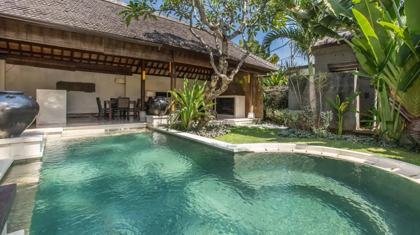 una villa con piscina y palmeras en Villa Air Bali Boutique Resort and Spa en Seminyak