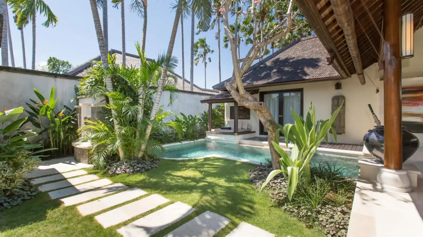 una sala de estar al aire libre con muebles blancos y patio en Villa Air Bali Boutique Resort and Spa en Seminyak