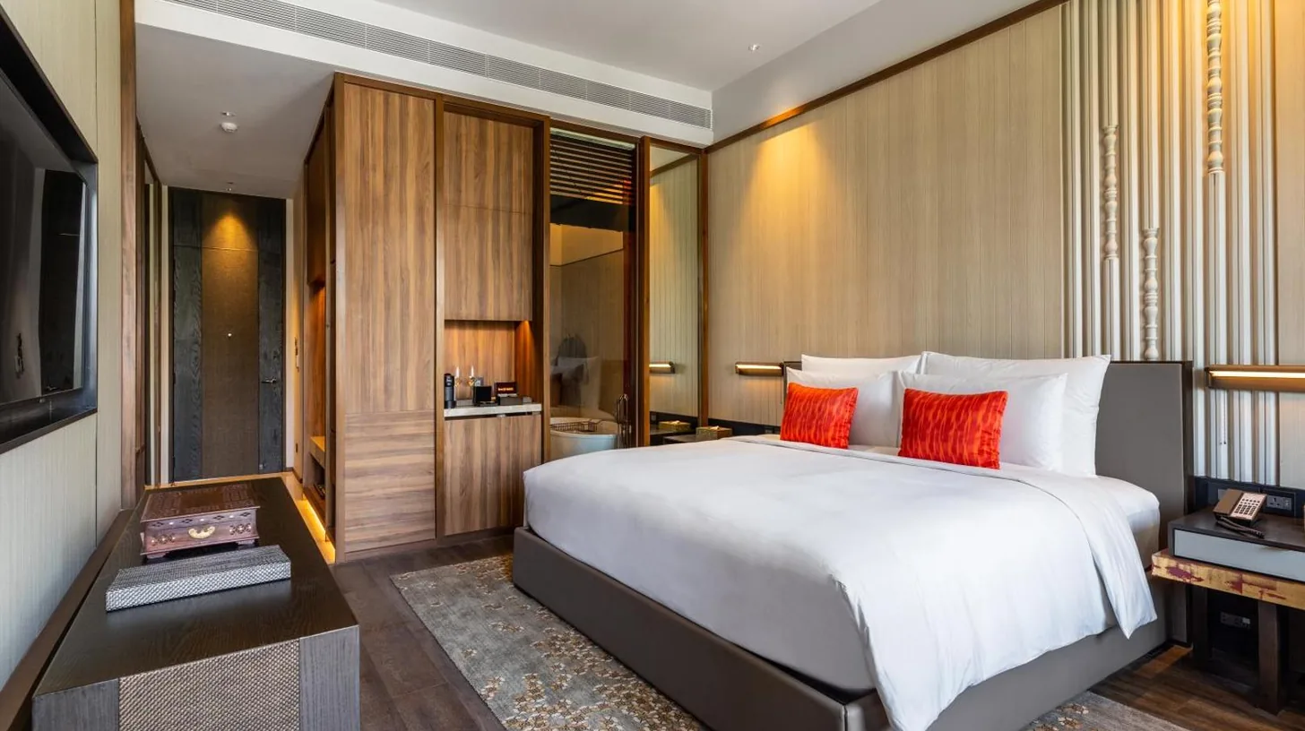 a bedroom with a large white bed with red pillows at Villa Deva Resort & Hotel Bangkok in Bangkok