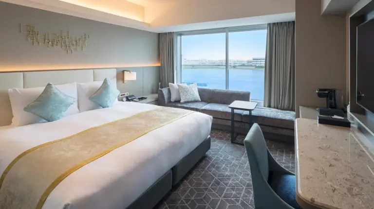 ein Hotelzimmer mit großem Bett und Sofa im Villa Fontaine Premier Haneda Airport – Direkt mit Terminal 3 des Haneda Airport verbunden in Tokio