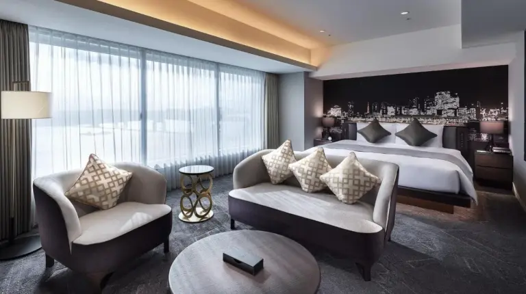 ein Hotelzimmer mit Bett, Sofa und Stühlen im Villa Fontaine Premier Haneda Airport – Direkt mit Terminal 3 des Haneda Airport verbunden in Tokio