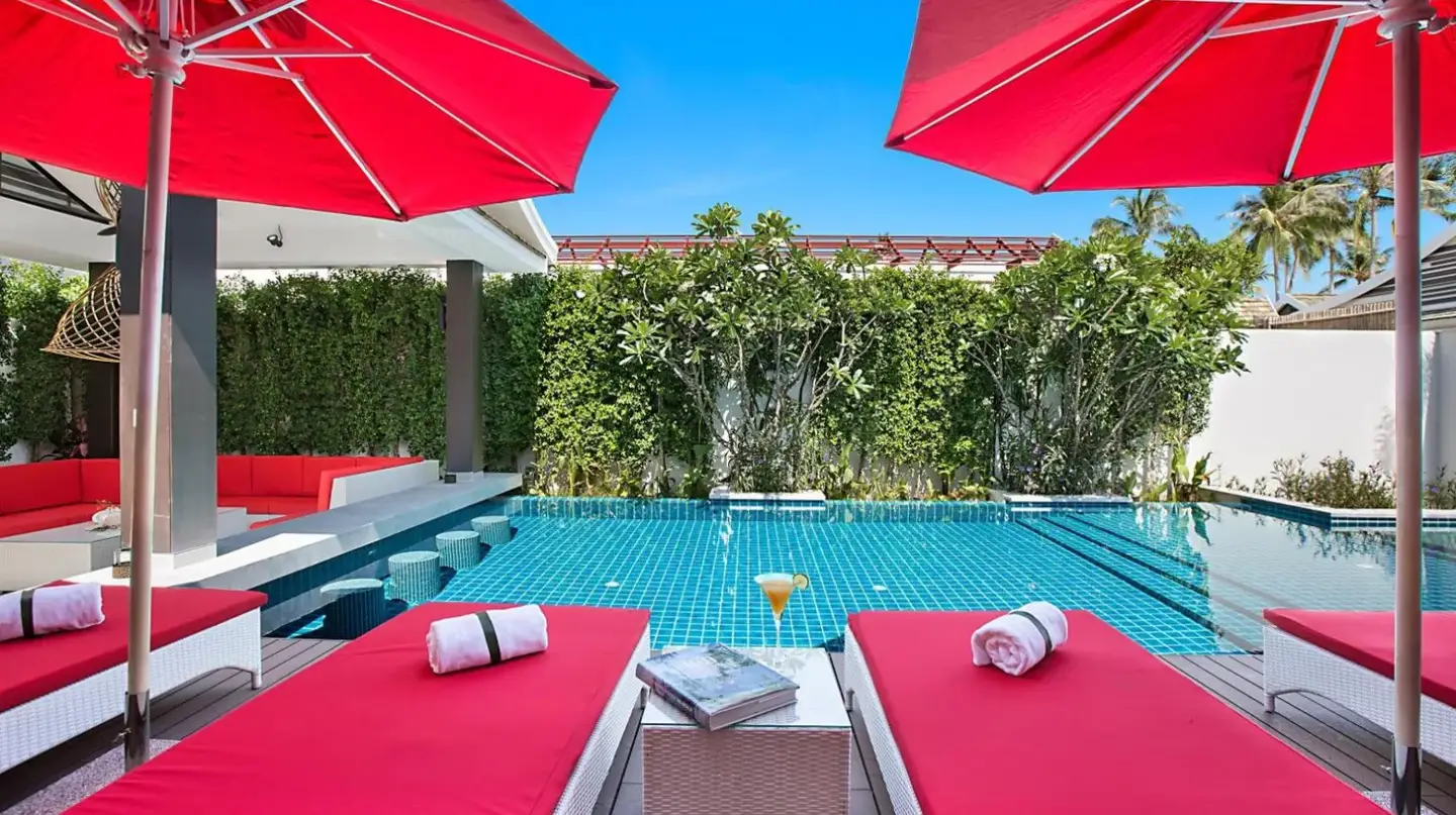 a swimming pool with red benches and a red umbrella at Villa Julia koh Samui beach with Cook and Majordome in Lamai