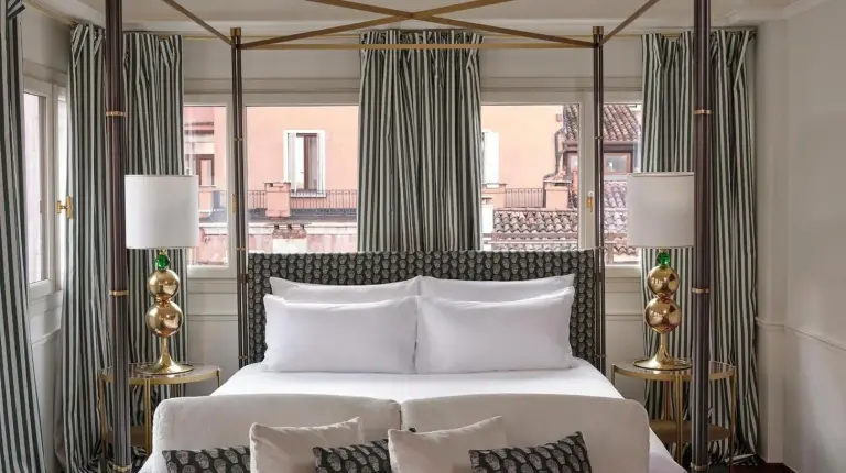 a bedroom with a large bed and a large window at Violino d'Oro Venezia in Venice