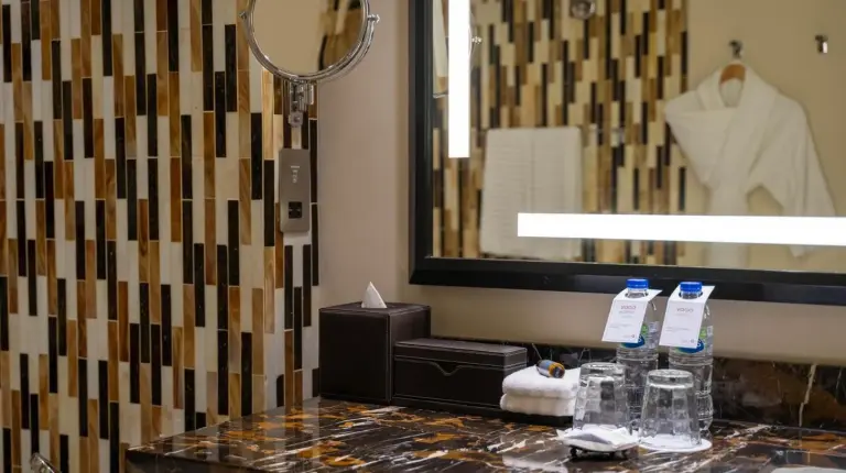 a bathroom with a sink and a tiled wall at VOGO Abu Dhabi Golf Resort & Spa in Abu Dhabi