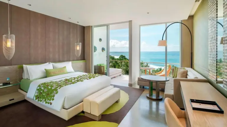 un baño con dos lavabos y una ducha con el océano en W Bali - Seminyak en Seminyak