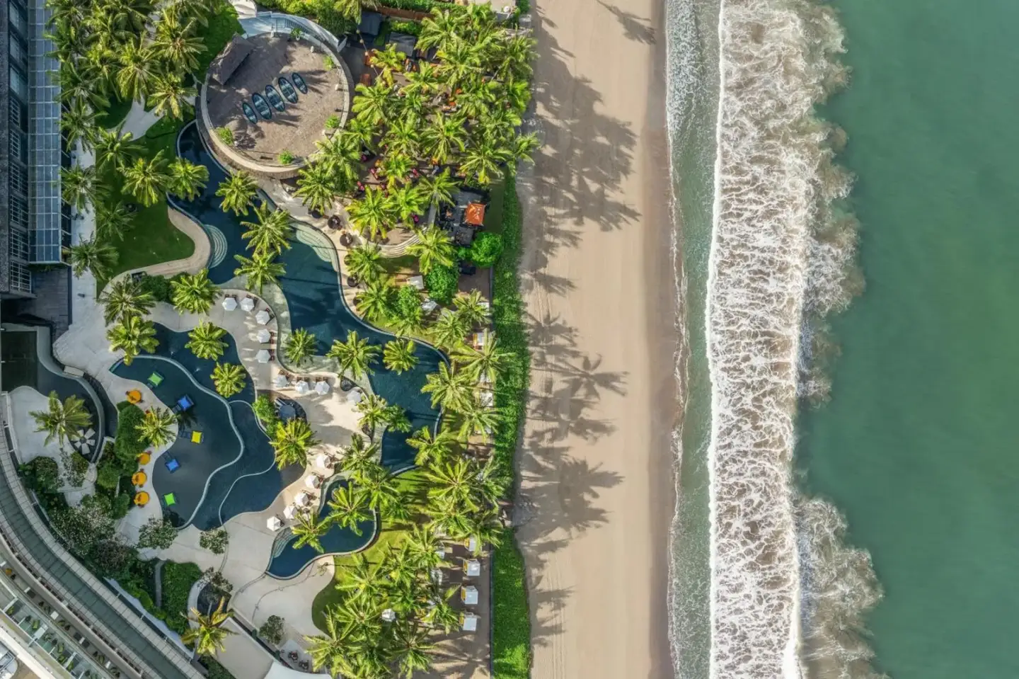 Vista aérea de W Bali - Seminyak mostrando palmeras exuberantes y acceso a la playa