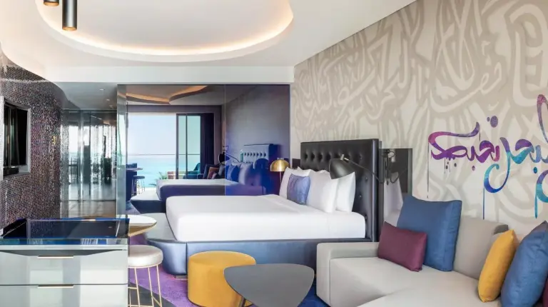 a hotel room with a bed and a couch at W Dubai - The Palm in Dubai