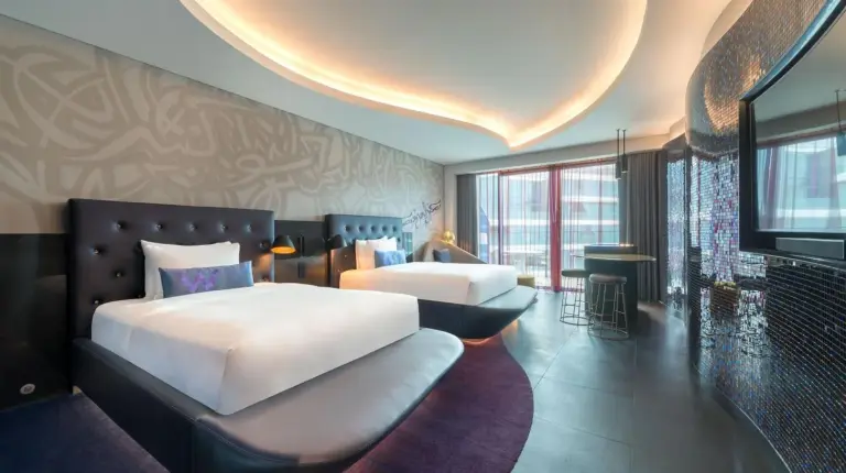 a hotel room with two beds and a couch at W Dubai - The Palm in Dubai