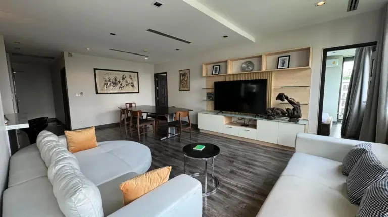 a living room with two white couches and a television at W8 CONDO