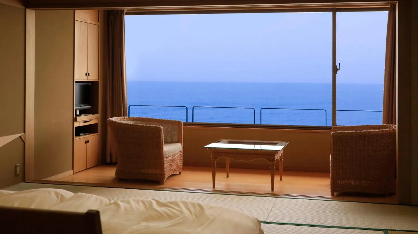 une chambre avec un lit et un balcon offrant une vue au Wakamatsu Hot Spring Resort à Hakodate