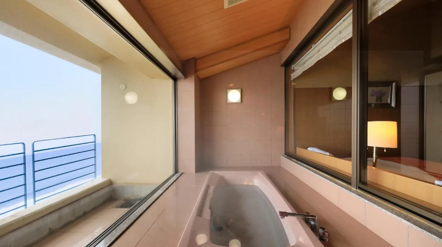 une baignoire dans une salle de bain avec une fenêtre au Wakamatsu Hot Spring Resort à Hakodate