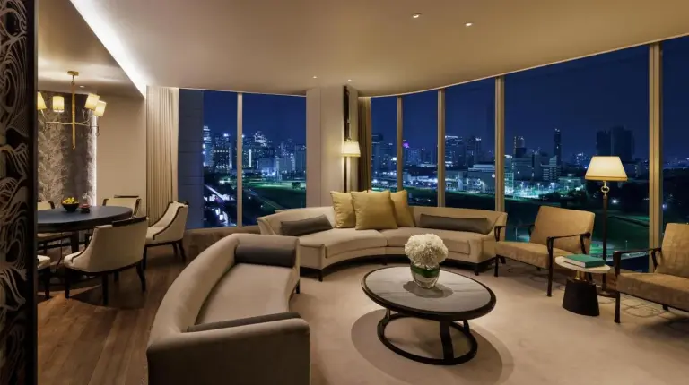 a living room with a couch and a table at Waldorf Astoria Bangkok in Bangkok
