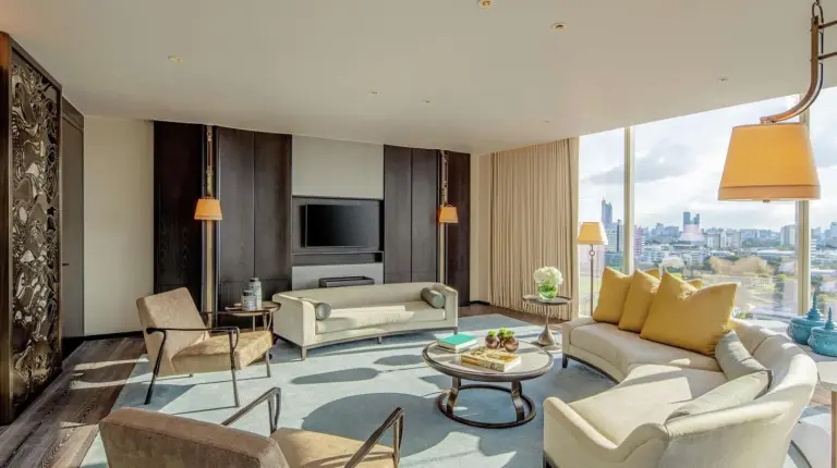 a living room filled with furniture and a large window at Waldorf Astoria Bangkok in Bangkok