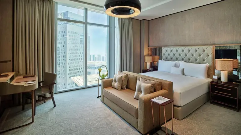 a bedroom with a bed and a couch and a desk at Waldorf Astoria Dubai International Financial Centre in Dubai