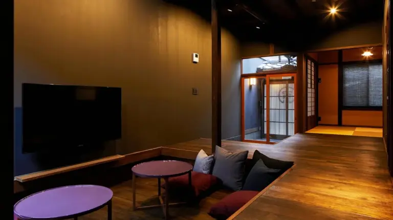 un salon avec deux tables et une télévision à écran plat à YADORU KYOTO HANARE Kanade No Yado à Kyoto