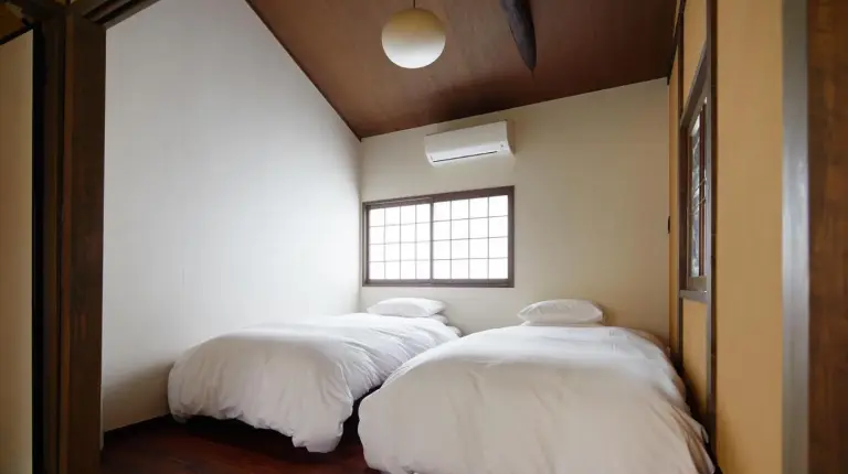 deux lits dans une chambre avec une fenêtre à YADORU KYOTO HANARE Kanade No Yado à Kyoto