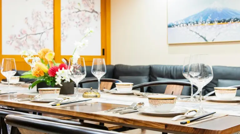 a table in a restaurant with wine glasses and flowers at YOKOHAMA STAY PREMIER in Yokohama