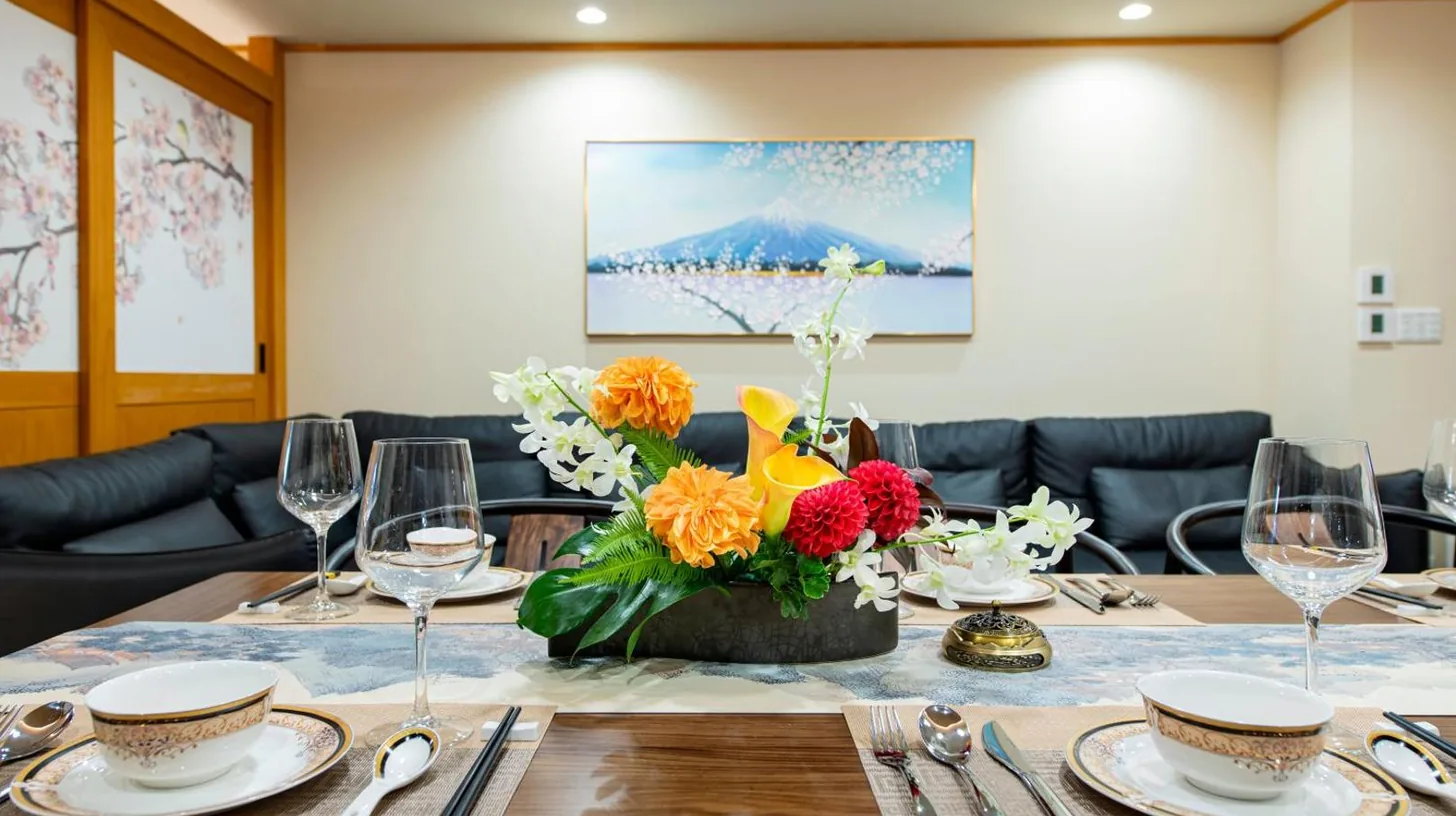 a dining table with a vase of flowers on it at YOKOHAMA STAY PREMIER in Yokohama