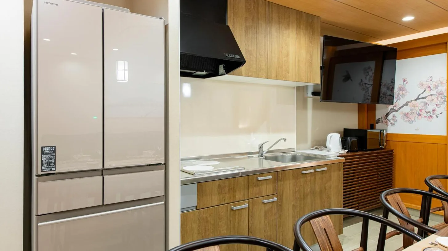 a kitchen with a refrigerator and a table with chairs at YOKOHAMA STAY PREMIER in Yokohama