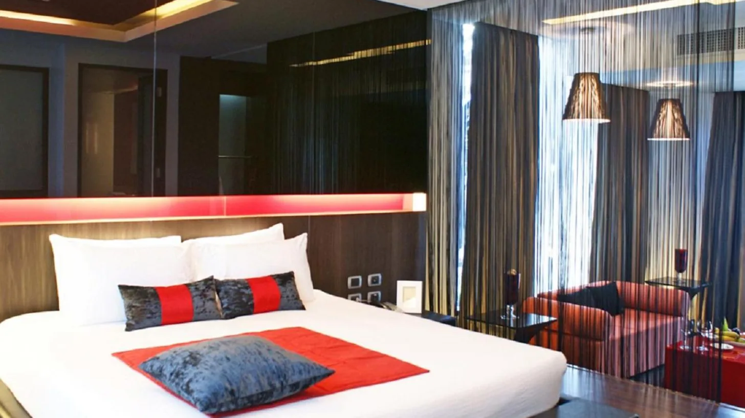 una habitación con una cama grande blanca y una silla en Z Through By The Zign en Pattaya Norte