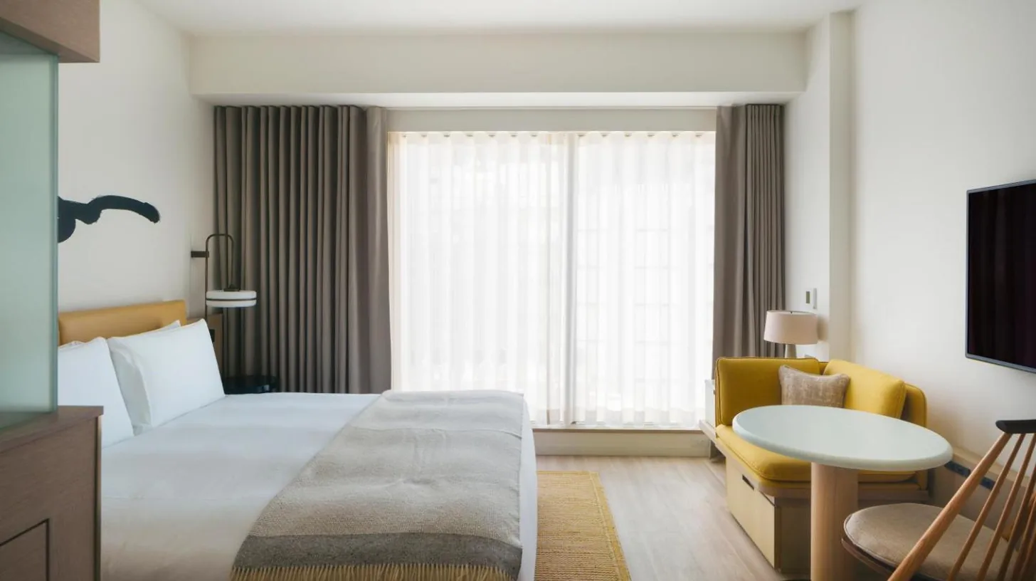 a hotel room with a large bed and a table at Zentis Osaka in Osaka