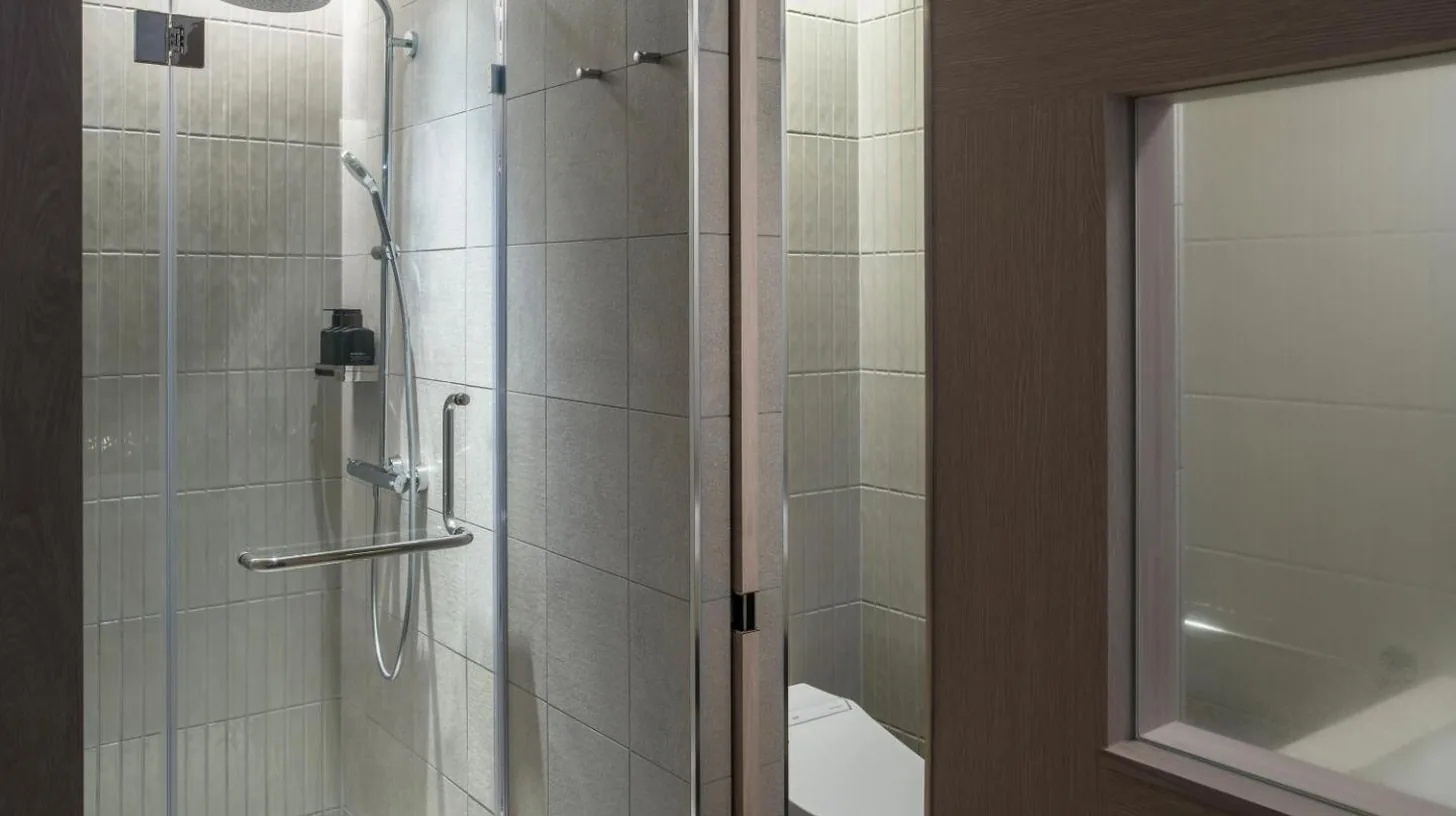 a bathroom with a shower with a glass door at Zentis Osaka in Osaka
